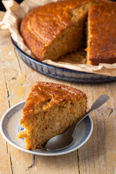 Tabakta ve kaşıkta servis yapmanın en üst görüntüsü, arka planda sünger keki ve seçici odak noktası, kırsal ahşap tahta, dikey