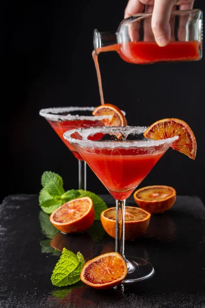 Close Two Cocktail Glasses Unfocused Bottle Serving Blood Orange Martini — Stock Photo, Image