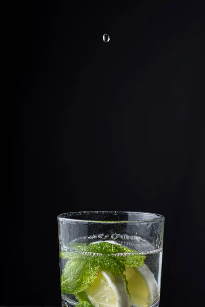 Top View Water Drop Falling Glass Cup Lemon Mint Black — Stock Photo, Image