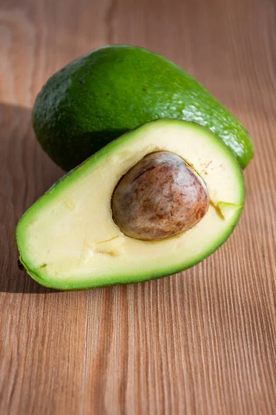 Close Van Een Halve Avocado Met Één Geheel Achter Houten — Stockfoto