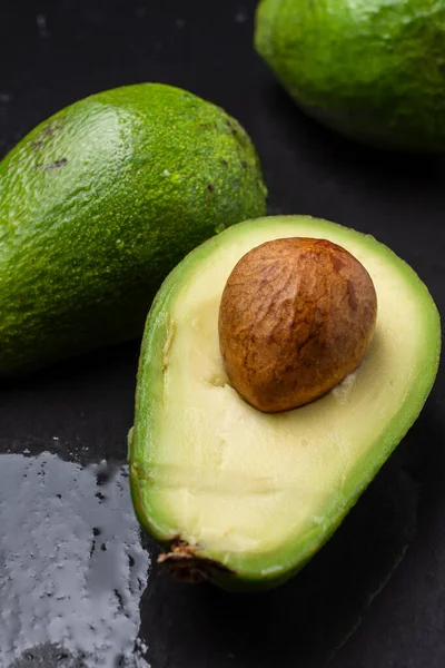 Luchtfoto Van Groene Avocado Één Met Zaad Natte Zwarte Leisteen — Stockfoto