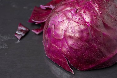 Dış tarafında ıslak kırmızı lahana parçacıkları ve seçici odaklı, siyah tahta üzerinde yatay olarak, kopyalama alanı ile yakın plan.
