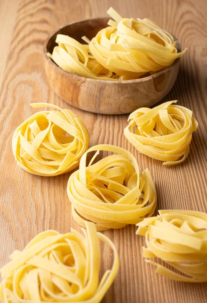 Aerial View Tagliatelle Nests Wooden Bowl Wooden Table Vertical — Stock Photo, Image