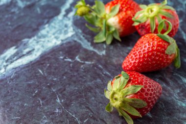 Mavi mermer üzerinde dört çilek üst görünümü, seçici odaklı, yatay olarak, kopyalama alanı ile