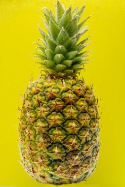 Suyun altındaki ananas, sarı arka planda kabarcıklarla kaplı.