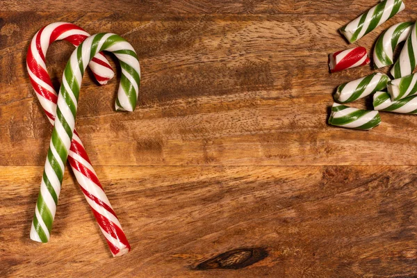 Cana de caramelo de doces de Natal em uma bandeja de madeira com caramelo quebrado — Fotografia de Stock