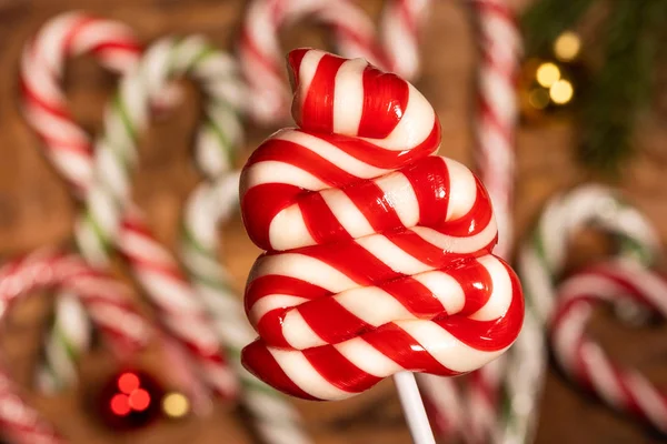 Christmas candy caramel on sticks in close-up on a background of caramel canes — Stock Photo, Image