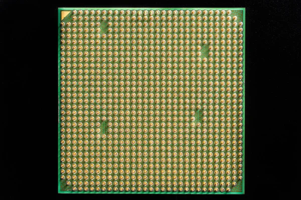 Stary procesor komputerowy ze złotymi nogami izolowany na czarnym tle — Zdjęcie stockowe