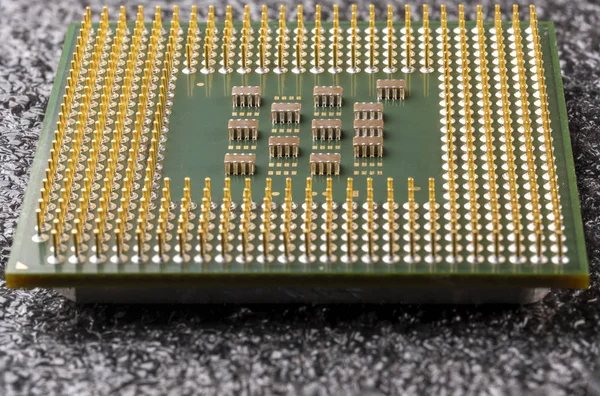 Antiguo procesador de computadora con patas chapadas en oro, microcircuitos en él, sobre un sustrato suave negro — Foto de Stock