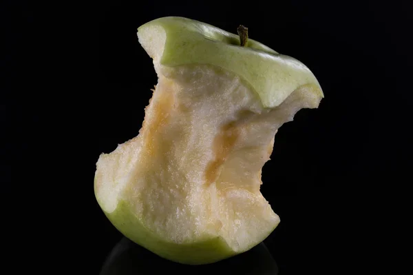 Stumpf eines grünen Apfels auf schwarzem Glashintergrund — Stockfoto