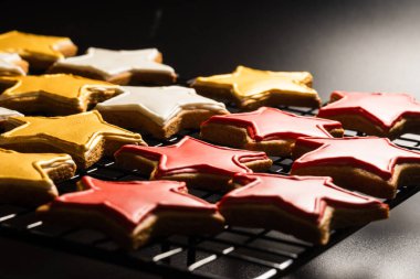 Siyah arkaplanda ızgarada yıldız şeklinde kurabiyeler.