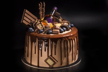 çeşitli şekerli kurabiyeler ve küçük bir şişe alkollü yabanmersinli kek ve çikolata damlaları, yakın plan.