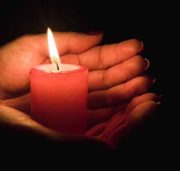 在黑暗中握住燃烧的蜡烛的女性手 — 图库照片