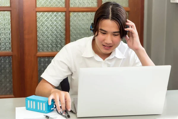 Student studeren en het schrijven van notities in een notitieblok zitten aan een bureau op hom — Stockfoto