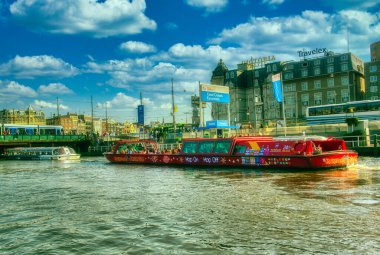 Amsterdam, Hollanda - 15 Nisan 2015: Amsterdam 'da kimliği belirsiz insanların bulunduğu tipik kanal manzarası. Amsterdam Hollanda 'nın başkenti ve en kalabalık şehridir.