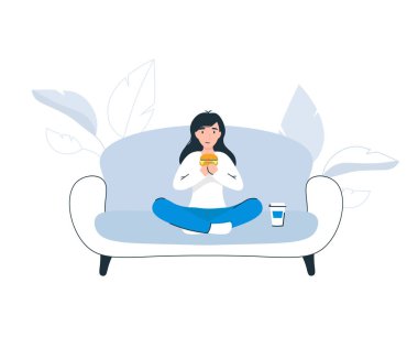 Kanepede hamburger yiyen kadın.