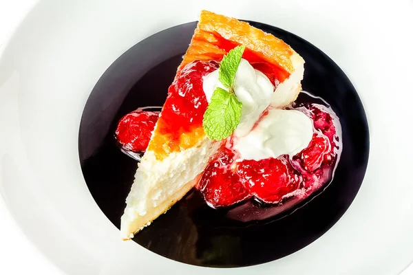 white black round plate, cheesecake juicy, raspberry sauce, strawberries, cream fresh white, fried, fresh herbs isolated on white background