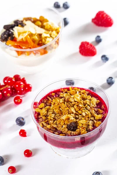 White isolated background, in a plastic transparent package or plate, sweet dessert, raspberry granola with nuts mexican fruit cups, berries