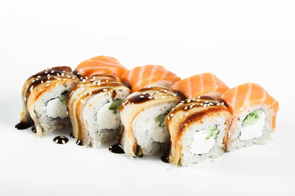 sushi rolls with red fish and bacon, teriyaki sauce, sesame seeds, on an isolated white background