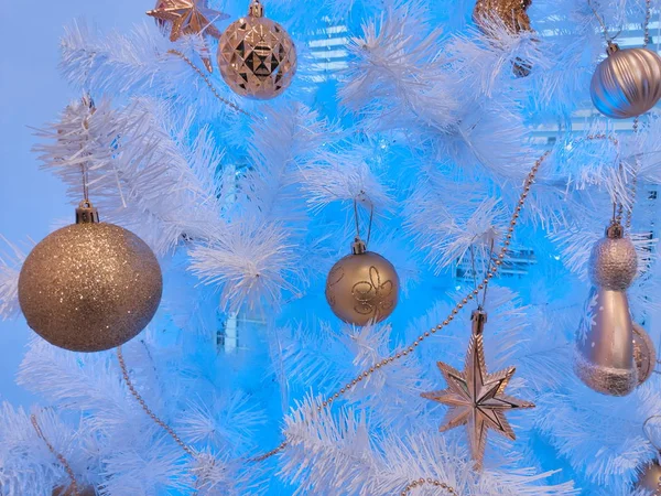 Goldene Weihnachtskugeln und Sterne auf weißen Zweigen auf blauem Grund. Hintergrund für Neujahrsgrüße. — Stockfoto