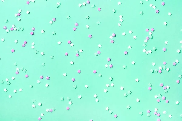 Pequeñas estrellas confeti sobre fondo de menta —  Fotos de Stock