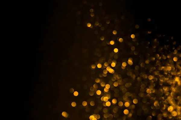 Bokeh abstrato dourado no fundo preto. — Fotografia de Stock