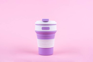 Pembe arka planda yeniden kullanılabilir kahve fincanı.