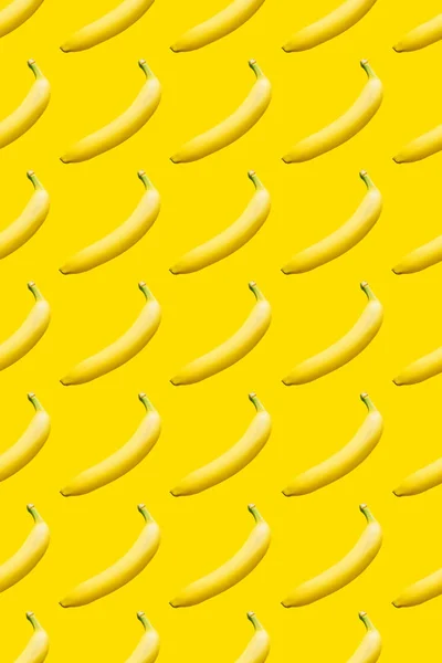 Patrón de plátanos maduros sobre un fondo amarillo . — Foto de Stock