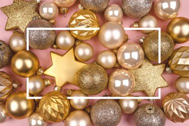Altın ve gümüş noel balolarıyla şenlikli pembe arka plan.