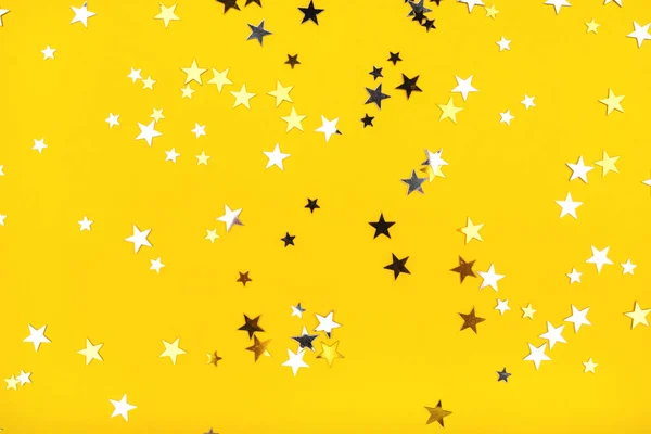 Gouden en zilveren sterren op gele achtergrond. — Stockfoto