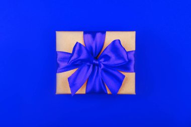 Mavi arka planda fiyonklu karton hediye kutusu.