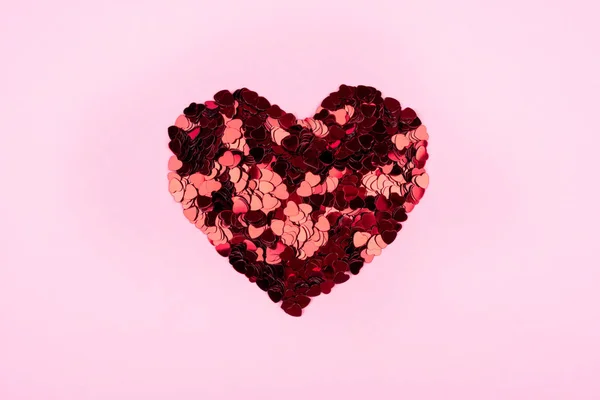 Сердце маленьких красных сердец на розовом фоне . — стоковое фото