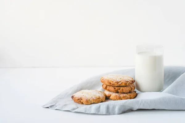 Gestapelte Kekse auf einer Leinenserviette und einem Glas Milch. — Stockfoto