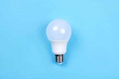 Mavi arka planda ampul var. Enerji tasarrufu kavramı.
