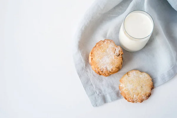 Biscoitos empilhados em um guardanapo de linho e um copo de leite . — Fotografia de Stock