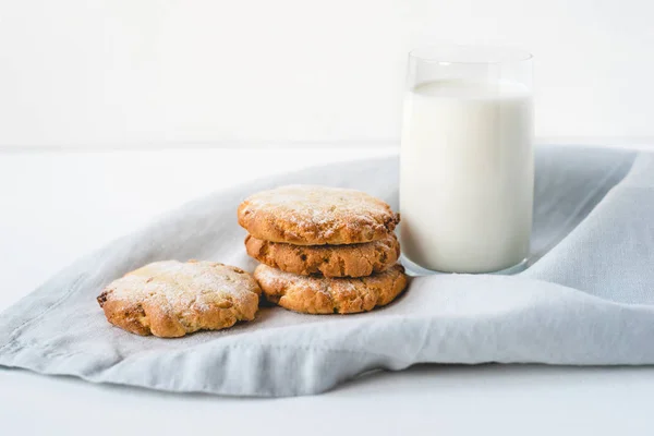 Stacked cookies on a linen napkin and a glass of milk. — Stock Photo, Image