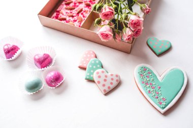 Beyaz masadaki bir kutuda el yapımı şekerlerle hazırlanmış hediye seti.