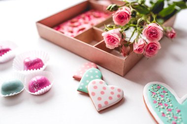 Beyaz masadaki bir kutuda el yapımı şekerlerle hazırlanmış hediye seti.