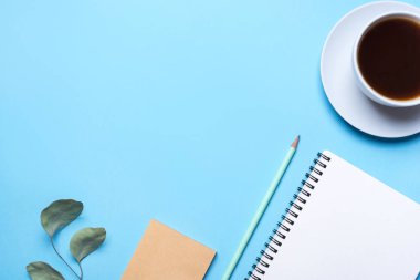 Not defteri, kalem ve kahve ile mavi arkaplan.