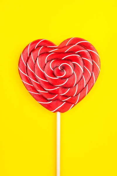 A heart-shaped lollipop on a yellow background. — 스톡 사진