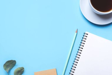 Not defteri, kalem ve kahve ile mavi arkaplan.