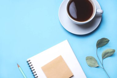 Not defteri, kalem ve kahve ile mavi arkaplan.