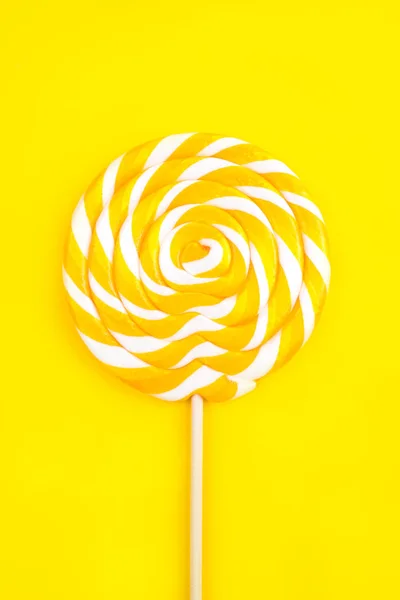 Yellow lollipop in the shape of a circle on a yellow background. — 스톡 사진