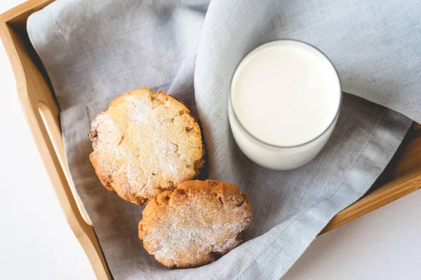 Biscoitos empilhados em um guardanapo de linho e um copo de leite . — Fotografia de Stock