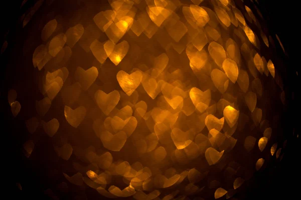 Dark background with golden bokeh in the shape of a heart. — 스톡 사진
