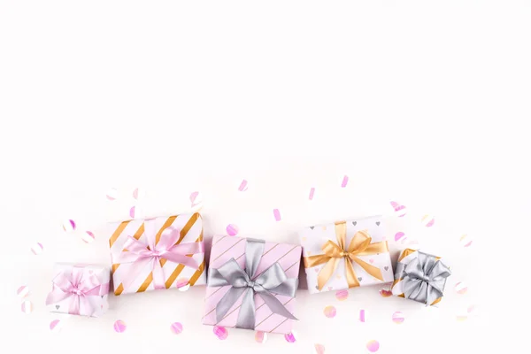 Set of gift boxes with bows and confetti on a white background.