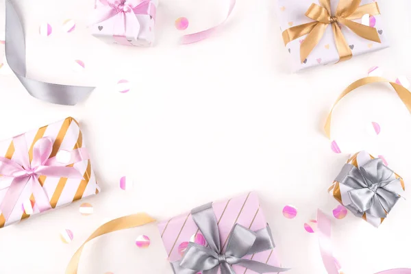 Varias cajas de regalo con lazos y confeti sobre un fondo blanco . — Foto de Stock