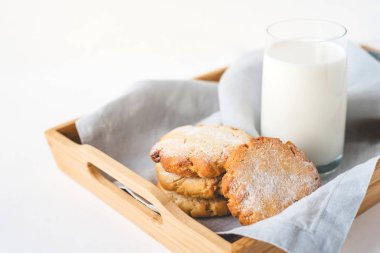 Keten bir peçete ve bir bardak süte istiflenmiş kurabiyeler..