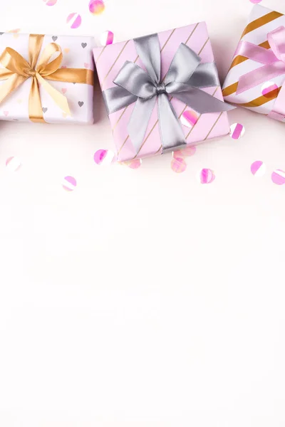 Caixas de presente com arcos e confetes em um fundo branco . — Fotografia de Stock