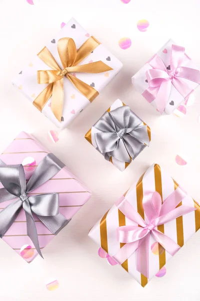 Set of gift boxes with bows and confetti on a white background.